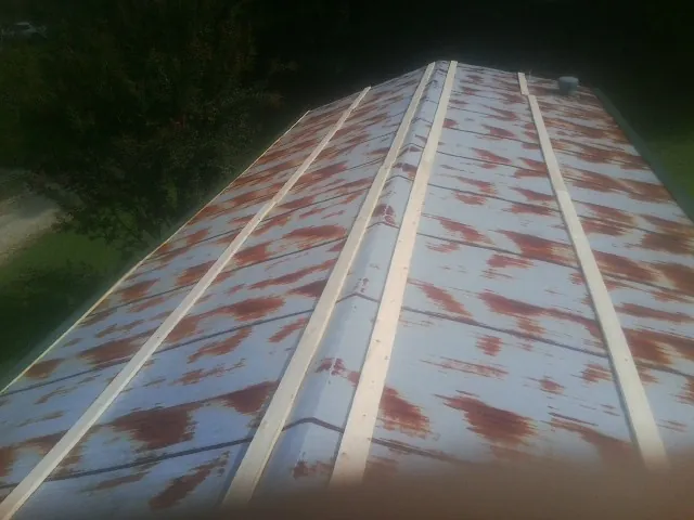 Rusted metal roof panels with new wood purlins before replacement — Storm Damage Roof Repair in Groton by Roofing Brothers